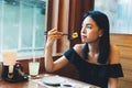 Attractive Asian woman sitting and eating Japanese food alone in the restaurant. Royalty Free Stock Photo