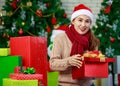 Attractive Asian woman wearing winter outfit and Santa`s hat unboxing gifts celebrating Christmas with joy. Decorated Christmas Royalty Free Stock Photo