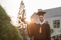 Attractive Asian Women Student Graduate in cap and gown celebrating with certificate in hand and so proud Royalty Free Stock Photo