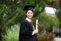 Attractive Asian Women Student Graduate in cap and gown celebrating with certificate in hand and so proud happiness Royalty Free Stock Photo