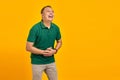 Attractive asian young man laughing out loud at funny on yellow background Royalty Free Stock Photo