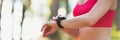 Attractive athlete using fitness app on her smart watch to monitor workout performance. Web banner.