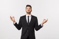 An attractive athletic businessman doing a yoga pose against white background. Royalty Free Stock Photo