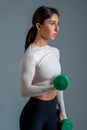 Girl doing dumbbell bicep curl on grey background Royalty Free Stock Photo