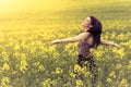 Beautiful woman in meadow of yellow twist from behind