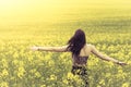 Beautiful genuine woman in sunny summer meadow from behind right
