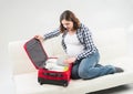 Attractive awaiting woman packing children's clothes into bag Royalty Free Stock Photo