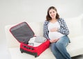 Attractive awaiting woman packing children's clothes Royalty Free Stock Photo