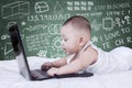 Attractive baby using laptop with scribble background