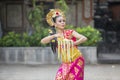 Attractive Balinese dancer throws frangipani flowers