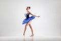 Attractive ballerina with bun collected hair wearing blue dress