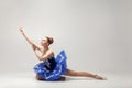 Attractive ballerina with bun collected hair wearing blue dress