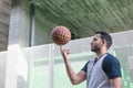 Attractive basketball player plays spinning his ball on a finger of his right hand while walking