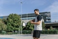 An attractive basketball player takes a break and looks at his mobile phone