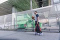 Attractive basketball player walks through an urban area carrying his red backpack and orange ball