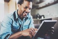 Attractive bearded African businessman using tablet while sitting on sofa at his modern home.Concept of young people Royalty Free Stock Photo