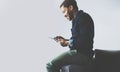 Attractive bearded African man using tablet while sitting on the sofa at his modern home office.Concept of young people Royalty Free Stock Photo