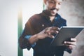Attractive bearded African man using tablet while standing at his modern home office.Concept of young people enjoying Royalty Free Stock Photo
