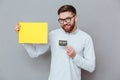 Attractive bearded businessman holding copyspace blank and debit card Royalty Free Stock Photo