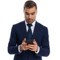 attractive bearded businessman in navy blue suit reading emails Royalty Free Stock Photo