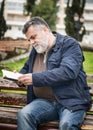 Attractive bearded man reading in a park Royalty Free Stock Photo