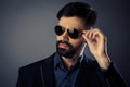 Attractive bearded man in suit touching his glasses Royalty Free Stock Photo