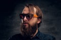 Attractive bearded man in sunglasses over dark background. Royalty Free Stock Photo