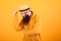 Attractive bearded man touching his hat over yellow background Royalty Free Stock Photo
