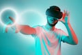 Attractive bearded man trying VR headset and poniting. Young man exploring another world with virtual reality goggles on