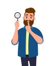 Attractive bearded young man holding magnifying glass and asking silence, keep quiet, shh, silence please! Search, find, discovery