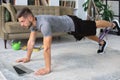 Attractive beared man doing plank exercise at home. Fitness is the key to health