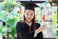 Attractive Beautiful Asian Graduated woman in cap and gown smile with certificated feeling so proud