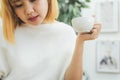 Attractive beautiful asian woman enjoying warm coffee in the kitchen at her home. Royalty Free Stock Photo