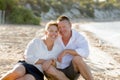 Attractive beautiful couple in love sitting on the beach in romantic summer holidays Royalty Free Stock Photo