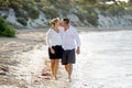 Attractive beautiful couple in love walking on the beach kissing in romantic summer holidays Royalty Free Stock Photo