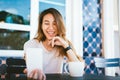 Attractive beautiful happy young Asian woman taking a selfie using a smart phone at cafe. Royalty Free Stock Photo