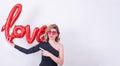 Woman holds love word shaped red balloon