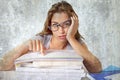 Attractive and beautiful tired student girl leaning on school books pile tired and bored after studying preparing exam looking was Royalty Free Stock Photo