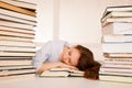 Attractive beautiful tired student sleeps on pile of books Royalty Free Stock Photo