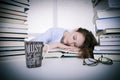 Attractive beautiful tired student sleeps on pile of books with Royalty Free Stock Photo