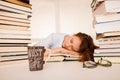 Attractive beautiful tired student sleeps on pile of books with Royalty Free Stock Photo