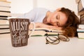 Attractive beautiful tired student sleeps on pile of books with Royalty Free Stock Photo