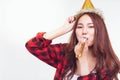 Attractive beautiful woman blowing party whistle and wears party hat for celebrating