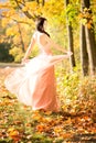 Attractive beautiful woman. Nature, autumn, fall yellow leafs. Fashion orange dress Royalty Free Stock Photo