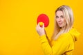 Attractive beautiful young blonde woman in casual yellow sporty clothes play ping pong, holding a ball and racquet Royalty Free Stock Photo