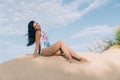 Attractive beautiful young girl having fun on the beach, posing lying on the sand, view from below, smiling broadly and Royalty Free Stock Photo