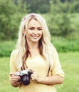 Attractive, young hippie girl taking pictures outdoors at summer. Holiday, vacation, hobby concept. Royalty Free Stock Photo