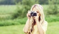 Attractive, young hippie girl taking pictures outdoors at summer. Holiday, vacation, hobby concept. Royalty Free Stock Photo