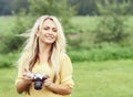 Attractive, young hippie girl taking pictures outdoors at summer. Holiday, vacation, hobby concept. Royalty Free Stock Photo