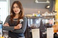 Attractive beauty asian female barista standing in front of counter and holding portafilter Royalty Free Stock Photo